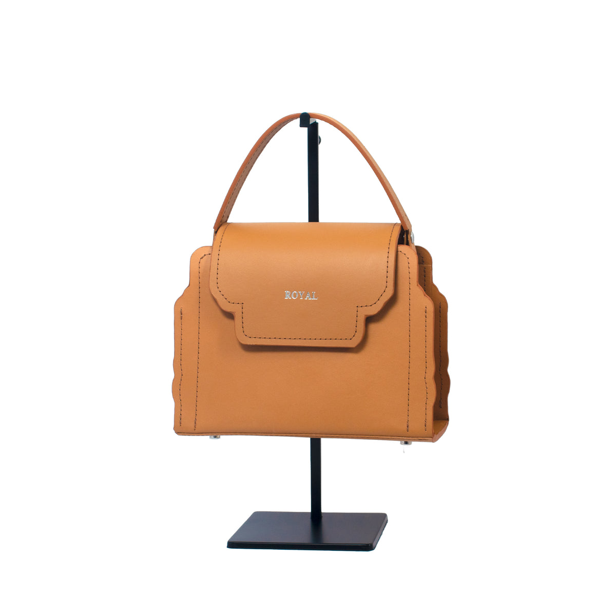 Hope full‑grain vegetable‑tanned leather handbag, hand‑painted in tan with a small, structured silhouette displayed on a stand