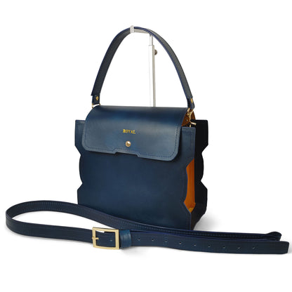 Hand‑painted full‑grain leather Bless shoulder bag satchel handcrafted in blue and orange color‑block with a structured silhouette and an artisan top handle.  