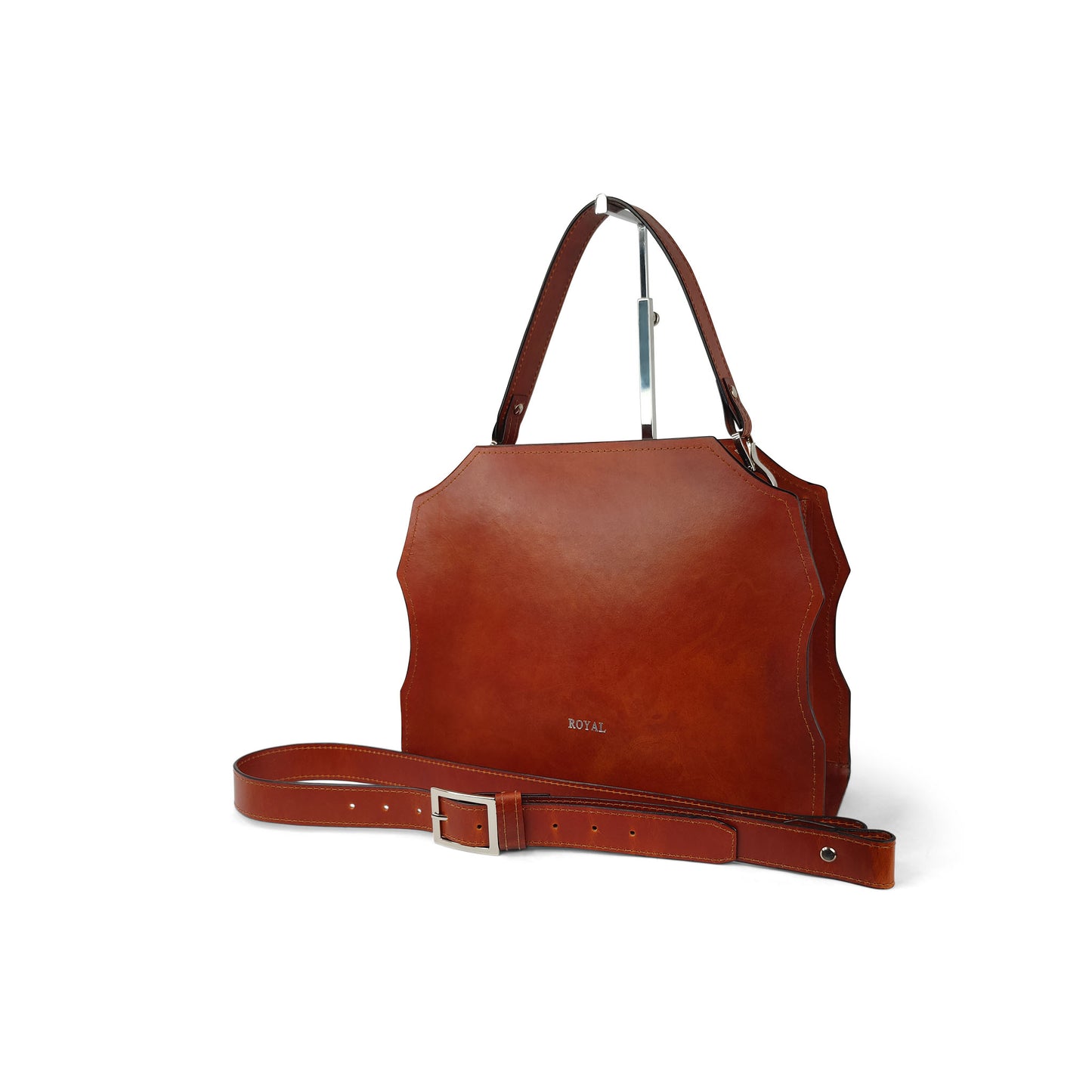 Hand‑painted full‑grain leather Forgiveness structured satchel handcrafted in cognac, shown in a front view on a stand with its top handle.  