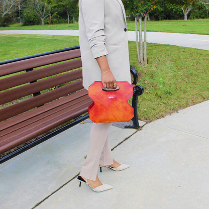 Hand‑painted full‑grain leather Miracle cut‑out handle bag handcrafted in red with artisan multi‑tone accents, held by a woman to highlight the design.  