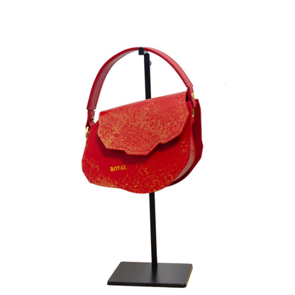 Charity hand‑painted full‑grain leather mini crossbody in red with gold accents in a close‑up view.  